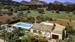 Une villa avec piscine, espace extérieur aménagé et vue sur les montagnes.