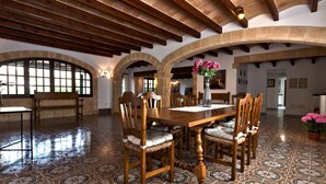 A spacious dining area with a large wooden table, multiple chairs, and a tiled floor. - GRAN VORAMAR CALA. 200 m2 pool and 6 bedrooms (Cala San Vicente)