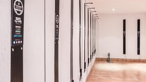 Eine an der Wand befestigte Fahrradverleihstation mit einem Schild, das 100% fahrradbezogene Leistungen anzeigt, darunter Strecken, Anstiege, Hotels, Veranstaltungen und die Möglichkeit zur Fahrradmiete.