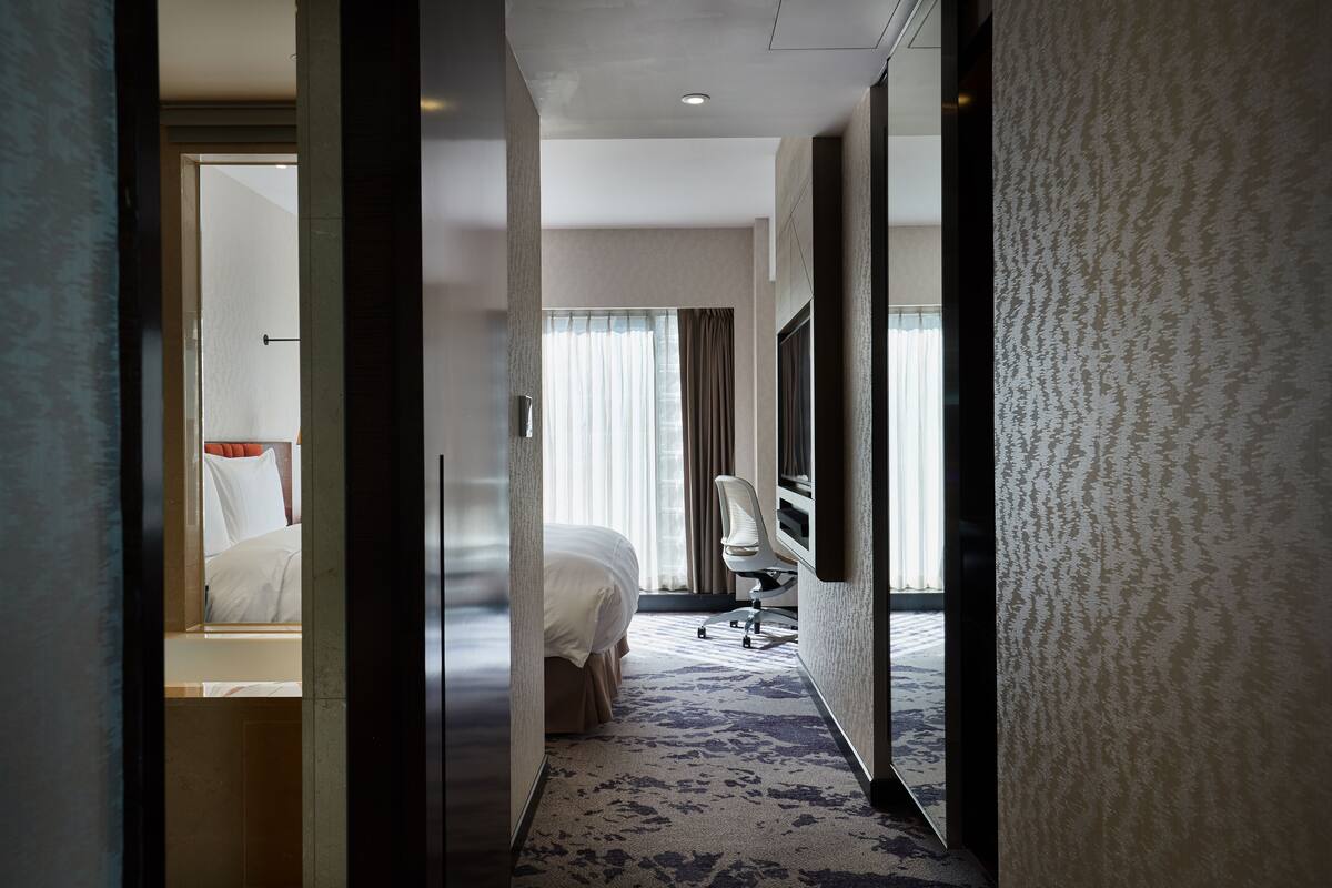 Une chambre d’hôtel avec un lit, un bureau et une chaise.