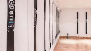 A wall-mounted bike rental station with a sign indicating 100% cycling services, including routes, climbs, hotels, events, and a bike rental option. - PINOS ALTOS 12. Lovely 1 bedroom apartment in Cala San Vicente (Cala San Vicente)