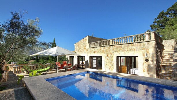 A swimming pool with a stone building in the background, a covered outdoor seating area, and a staircase leading to the building. - LLOP. Magnificent villa with sauna (Pollensa)