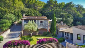 A stone villa with a tiled roof, a central courtyard, and a staircase leading to the entrance. - LLOP. Magnificent villa with sauna (Pollensa)