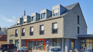 A modern building with a flat roof, multiple windows, and a ground-level entrance. - VR-Serviced Apartments Obergeis (Neuenstein)