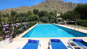 A pool with two lounge chairs, a mountain in the background, and a clear sky. - BOQUER PETIT ( PIEDRA ). Surrounded by nature, but close to Pto. Pollensa (Puerto Pollensa)