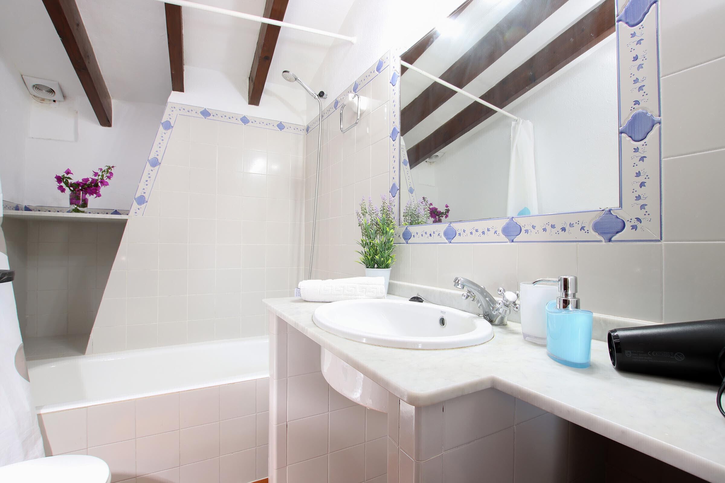 A bathroom with a white sink, a mirror, a shower, and a bathtub.