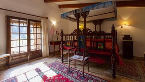 A traditional bedroom with a four-poster bed, a wooden chair, a red bedspread, and a patterned rug. - PLANA MORRO.  Characterful finca in beautiful countryside near Pollensa (Pollensa)