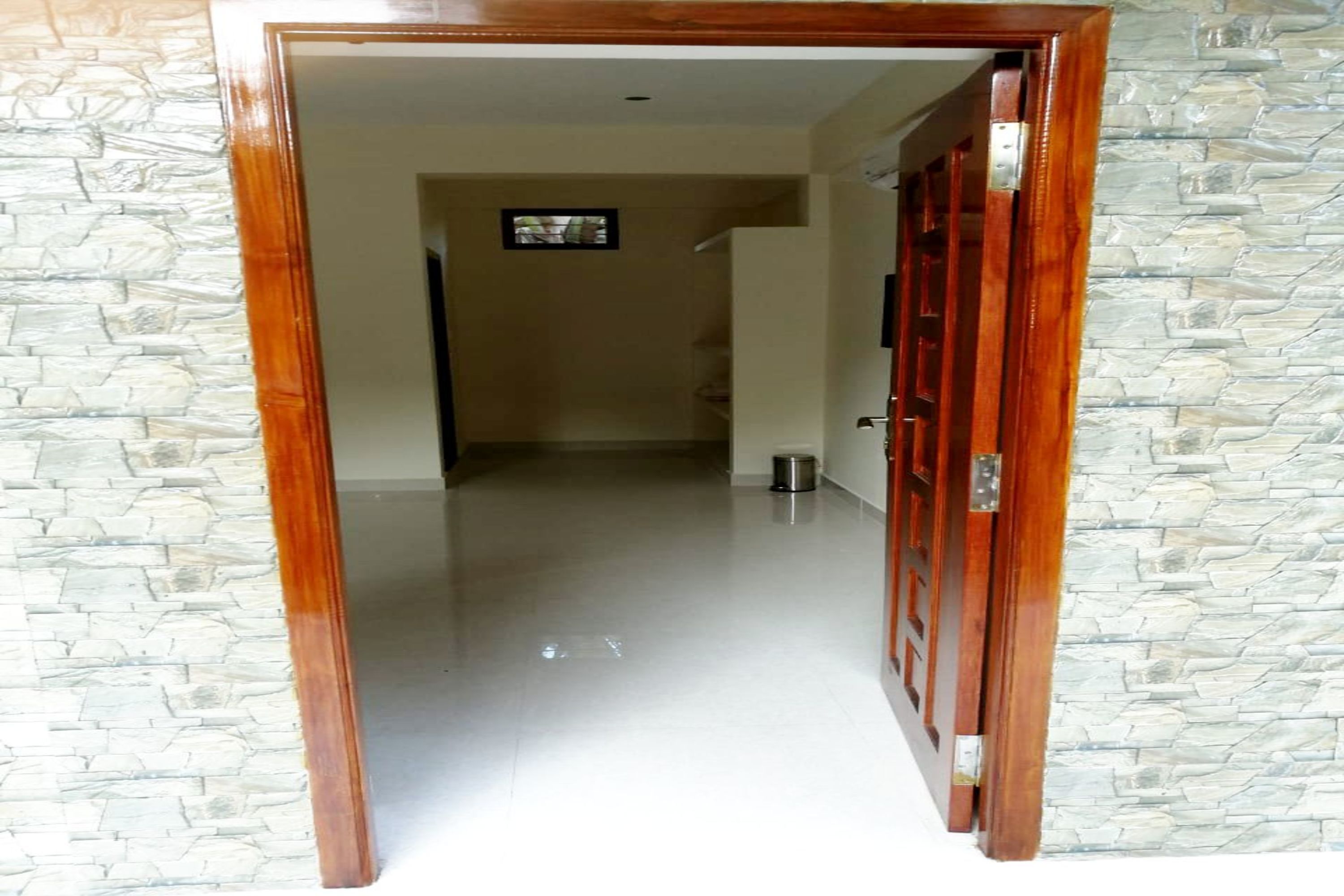 A hallway with a stone wall on one side and a wooden door on the other.