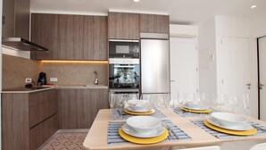 Una cocina moderna con armarios de madera, horno empotrado y refrigerador.