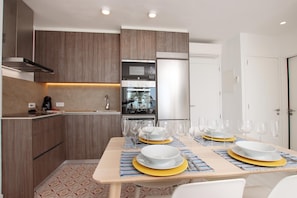 A modern kitchen with wooden cabinets, a built-in oven, and a refrigerator.