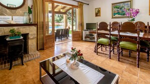 A dining area with a wooden table, chairs, and a fireplace. - SOL ROMA. 3 bedrooms villa near Pollensa (Pollensa)