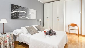 A bedroom with a bed, a nightstand, a chair, a wardrobe, and a painting on the wall. - matarolux2 · 25km from Barcelona , Beach 200 meters (Mataro)