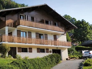Un bâtiment à deux étages doté de balcons en bois et d’une allée pavée.