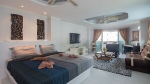 Una habitación de hotel moderna con una cama grande, un escritorio, una silla y un televisor.