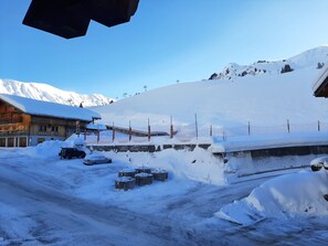 Schneebedecktes Berggebiet mit einem hölzernen Gebäude, auf dem 