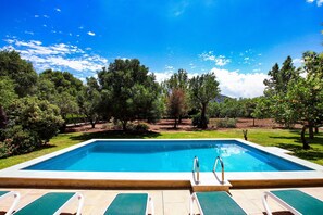 A rectangular pool with two ladders, surrounded by a lawn and trees. - PUNXA. Lovely stone-clad villa with large gardens surrounded by fruits and mountains (Pollensa)