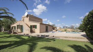 A building with a pool, green shutters, and a satellite dish.
