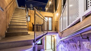 A staircase with a glass door leading to a lower level, a metal railing, and a wall-mounted air conditioning unit. - HORTA 55. Superb house 200 m from the town centre (Pollensa)
