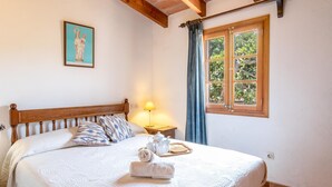 A neatly made bed with a white quilt, a wooden headboard, and a framed picture above it. - ROSA. Traditional villa near Pollensa town (Pollensa)