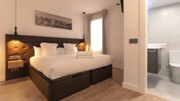 Habitación de hotel moderna con una cama grande, lámparas de noche, una mesita de noche, un cuadro colgado en la pared y vistas al baño.