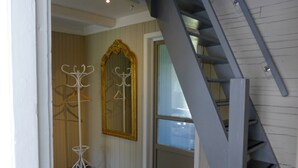 A staircase leading to a second floor, a coat rack with a mirror, and a door with a window. - Velfjord camping & hytter (Brønnøy)