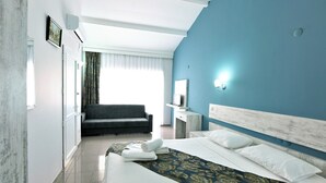A modern hotel room with a large bed, a sofa, a desk, and a mirror. - Afytos Kazdaglari Akcay (Edremit)
