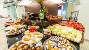Una mesa de buffet con diversos alimentos, incluyendo pasteles, frutas y un pastel.