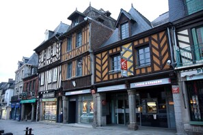 A row of traditional half-timbered buildings with storefronts, including a bank and a pawn shop. - Hotel de la Gare (Dol-de-Bretagne)