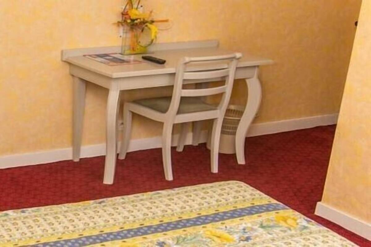 A room with a bed, a desk, and a chair.
