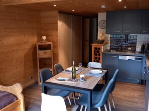 Une cuisine moderne avec des meubles gris, un four encastré et un évier.