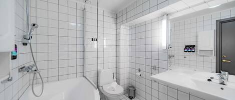 Une salle de bain moderne avec des carreaux blancs, une baignoire, des toilettes et un lavabo avec un miroir.