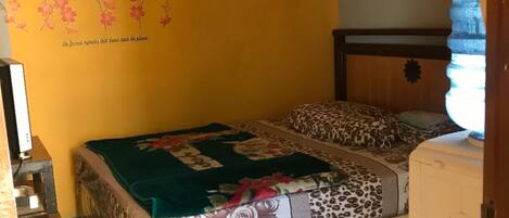 Un dormitorio con cama, armario y un adorno en la pared.