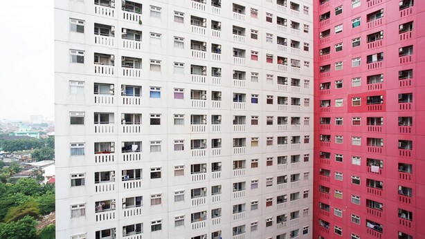 A high-rise building with multiple floors, each featuring balconies and windows. - Green Pramuka Apartement By Vici (Jakarta)