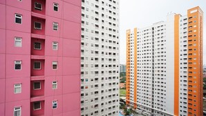 A high-rise building with multiple floors, featuring a mix of pink and white exteriors. - Green Pramuka Apartement By Vici (Jakarta)