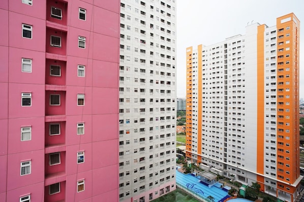 A high-rise building with multiple floors, featuring a mix of pink and white exteriors.