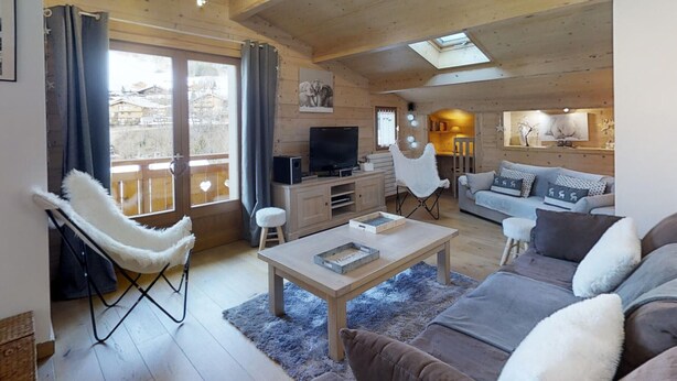 A cozy living room with a wooden ceiling, a sofa, a coffee table, and a TV. - Cozy apartment for 4 at the foot of the slopes (Le Grand-Bornand)