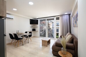 A modern apartment with a dining area, a living room with a sofa, and a kitchen. - Sun Moon Apartment 2 in the center of Rethymno town (Rethymno)
