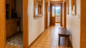 A hallway with wooden cabinets, a bench, and a view of mountains.