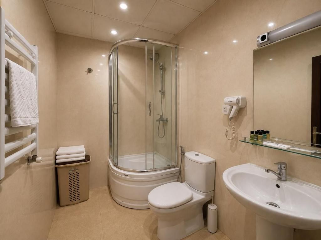 Une salle de bain moderne avec une douche à parois de verre, des toilettes, un lavabo et un porte-serviettes.