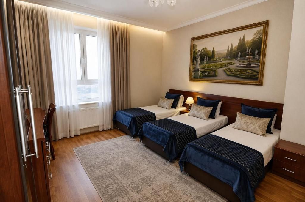 Habitación de hotel con dos camas, un cuadro en la pared y una ventana con cortinas.