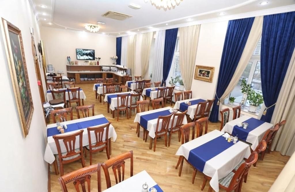 Un espace repas comprenant plusieurs tables et chaises, un téléviseur et un coin bar.