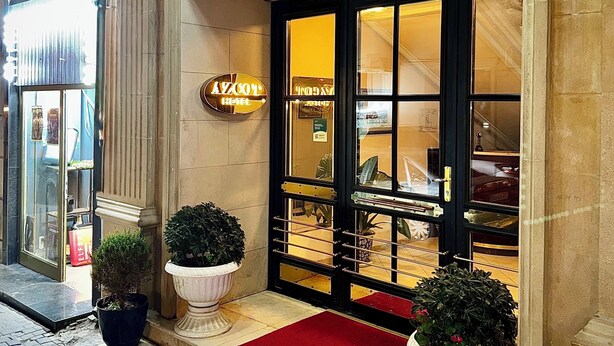 The exterior of the Azcot Hotel with a grand entrance, a red carpet, and potted plants. - Azcot Hotel - Nizami Street (Baku)