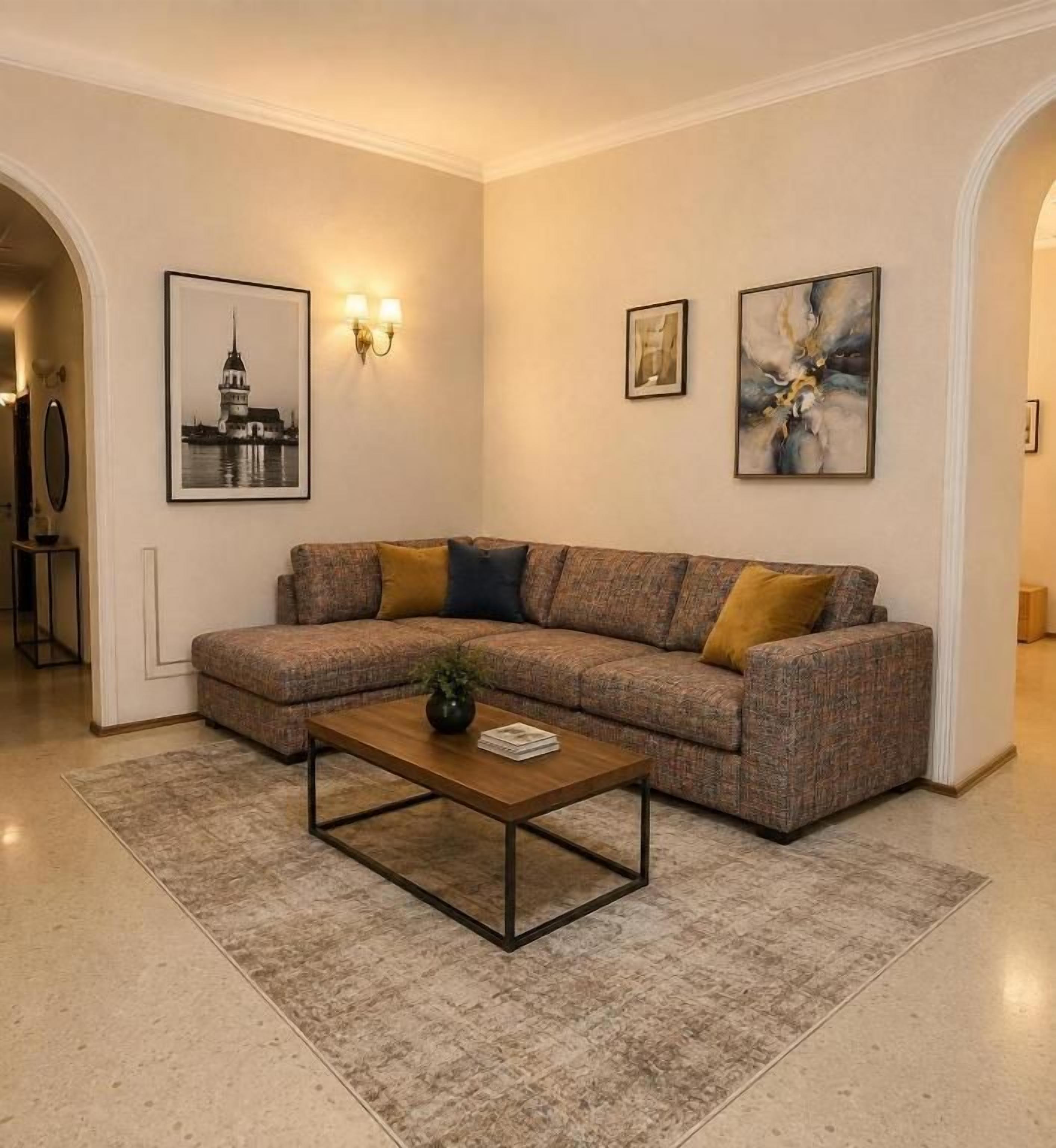 A living room with a sectional sofa, a coffee table, and framed artwork on the walls.