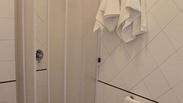 A bathroom with a shower enclosure, a bidet, and a toilet.
