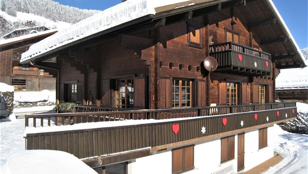 A wooden chalet with a balcony, snow-covered surroundings, and a clear sky. - Spacious apartment for 6 in Le Grand-Bornand (Le Grand-Bornand)