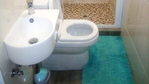 Une salle de bain avec un lavabo, des toilettes et une douche.