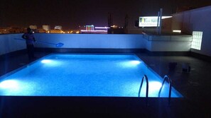 Een buitenzwembad en ligstoelen