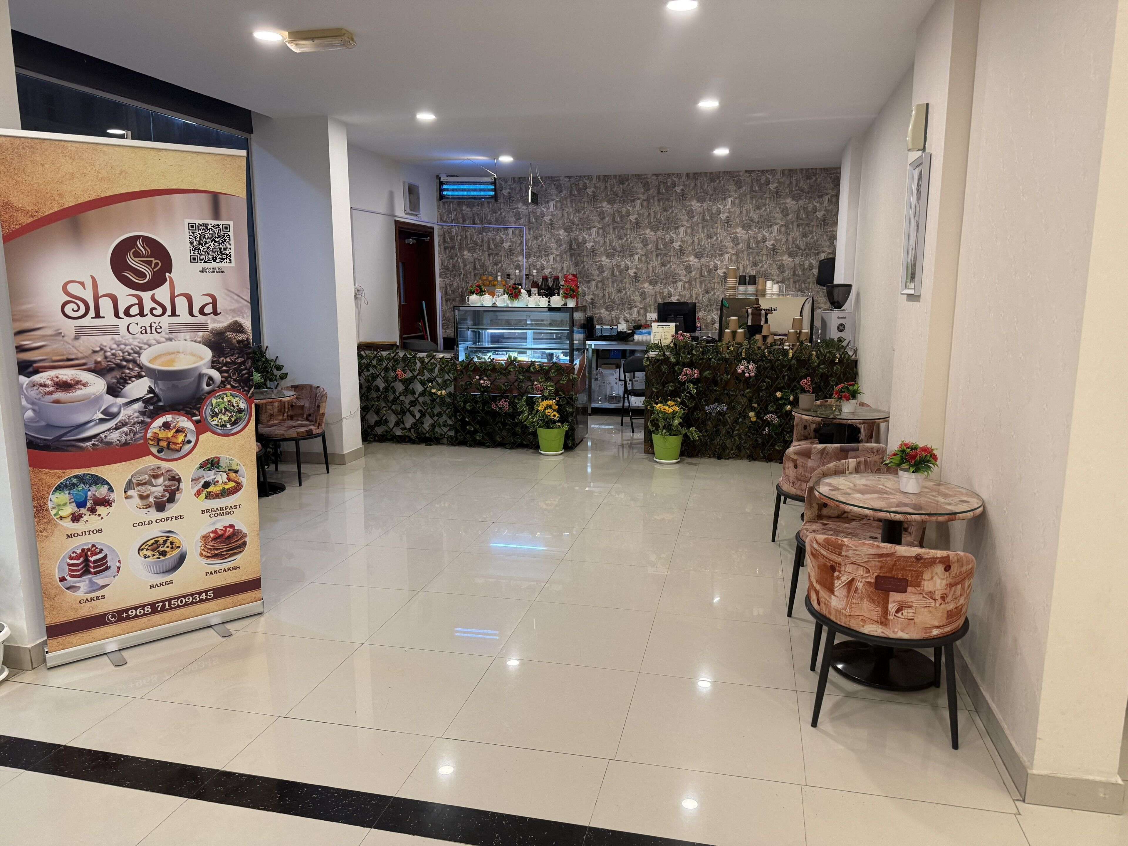 Ein Café-Interieur mit Theke, Sitzgelegenheiten und einem Speisekartenposter.