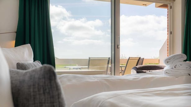Une chambre d’hôtel avec un lit, une chaise et une vue sur l’extérieur.