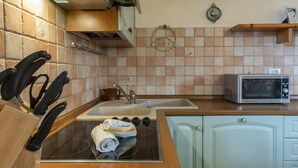 A kitchen with a sink, stove, and microwave. - Aria di Vacanza - Maltineddu COD 23 (Olbia)